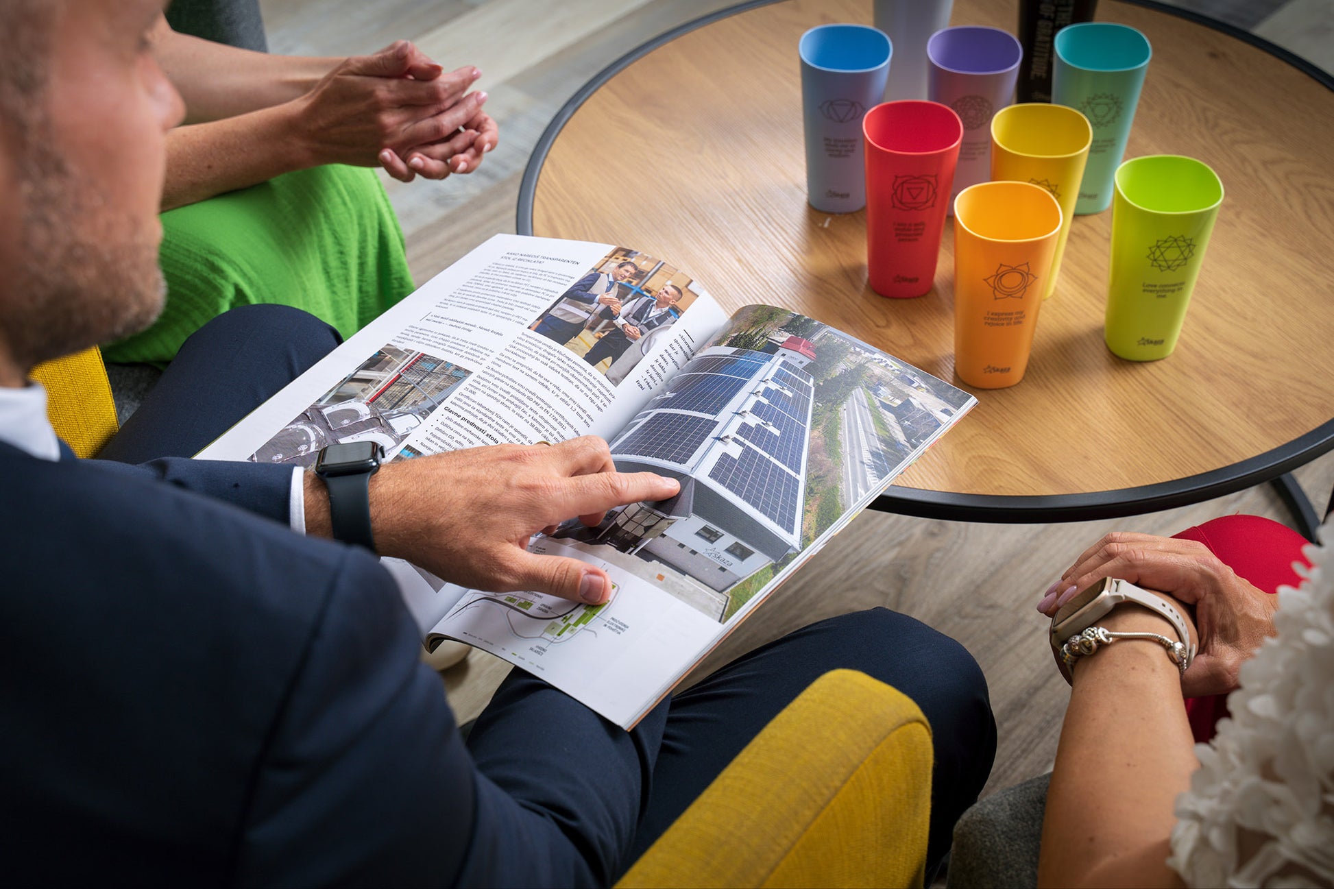 Ein Mann liest einen Katalog im Hintergrund, die Linie der 7 Chakren ist zu sehen