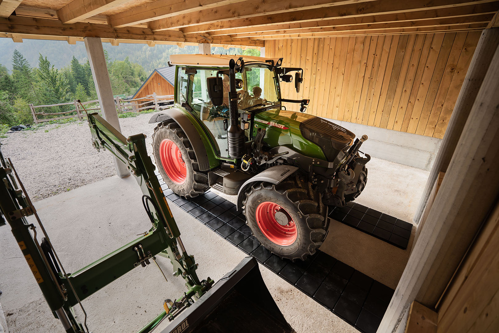 Der Traktor ist in der Garage auf Gehplatten geparkt, die den Betonboden schützen.