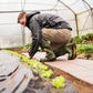 Gärtner arbeitet auf begehbaren Skaza Platten im Gewächshaus – ideal für Gemüseanbau und Gartenwege